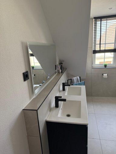 Modernes Badezimmer mit zwei Waschbecken und großem Spiegel an der Wand.
